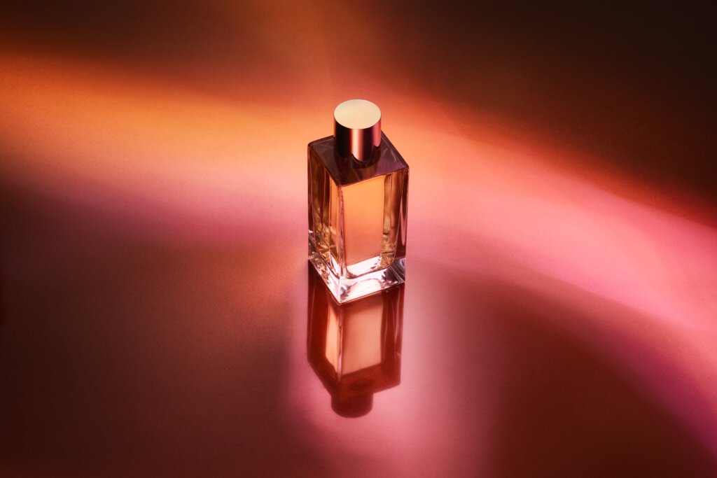 perfume bottle on red and orange background shot from the top